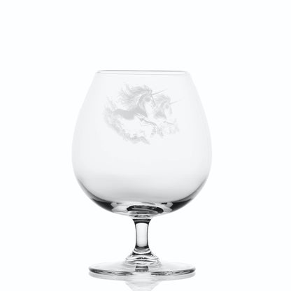 Clear glass brandy snifter with engraved unicorn design on a white background