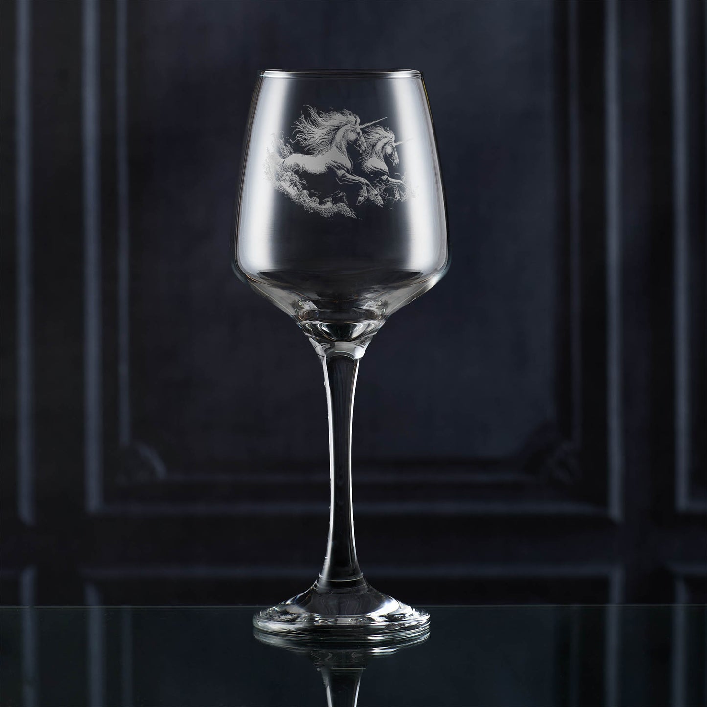 Wine glass with unicorn etching on a dark background