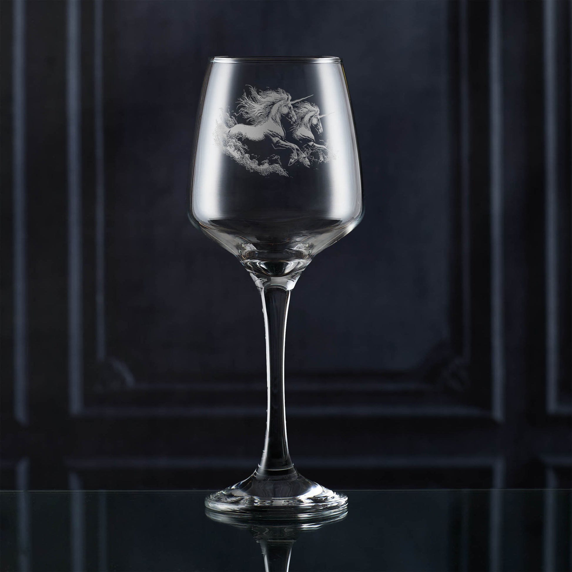 Wine glass with unicorn etching on a dark background