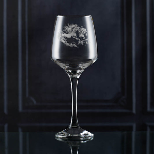 Wine glass with unicorn etching on a dark background