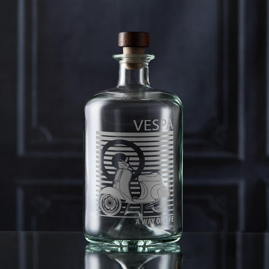 Clear glass bottle with Vespa Scooter on a dark background