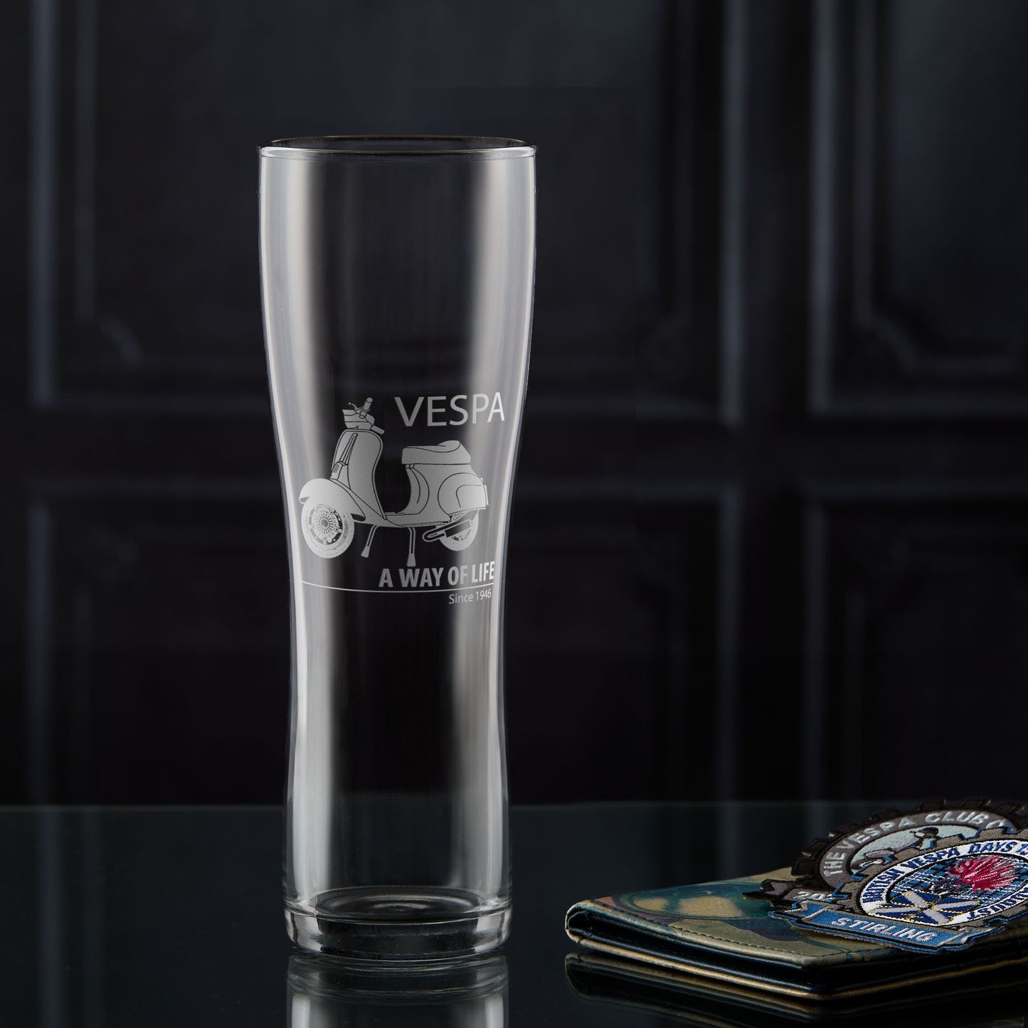 Pint glass engraved with a Vespa 50 Special scooter and 'A Way of Life' text on a dark background