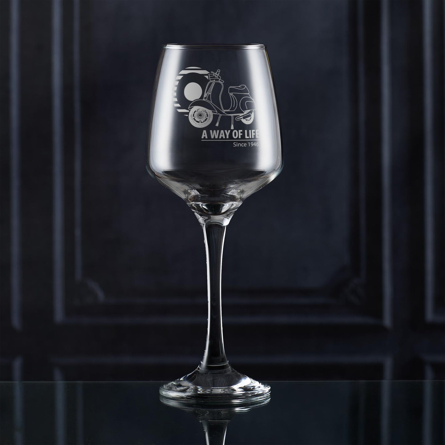 Engraved Vespa 50 Special wine glass with A Way of Life Since 1946 slogan, styled on dark background