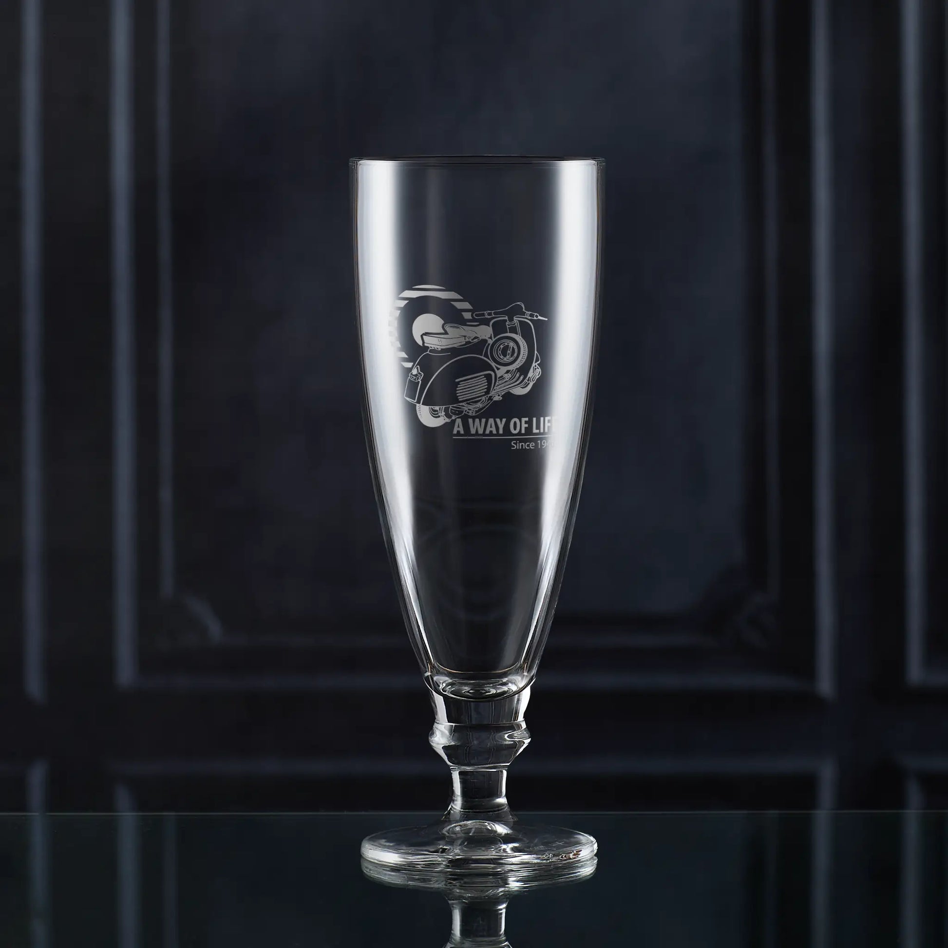 Stemmed beer glass engraved with Vespa GL scooter and Mod target, photographed on dark background