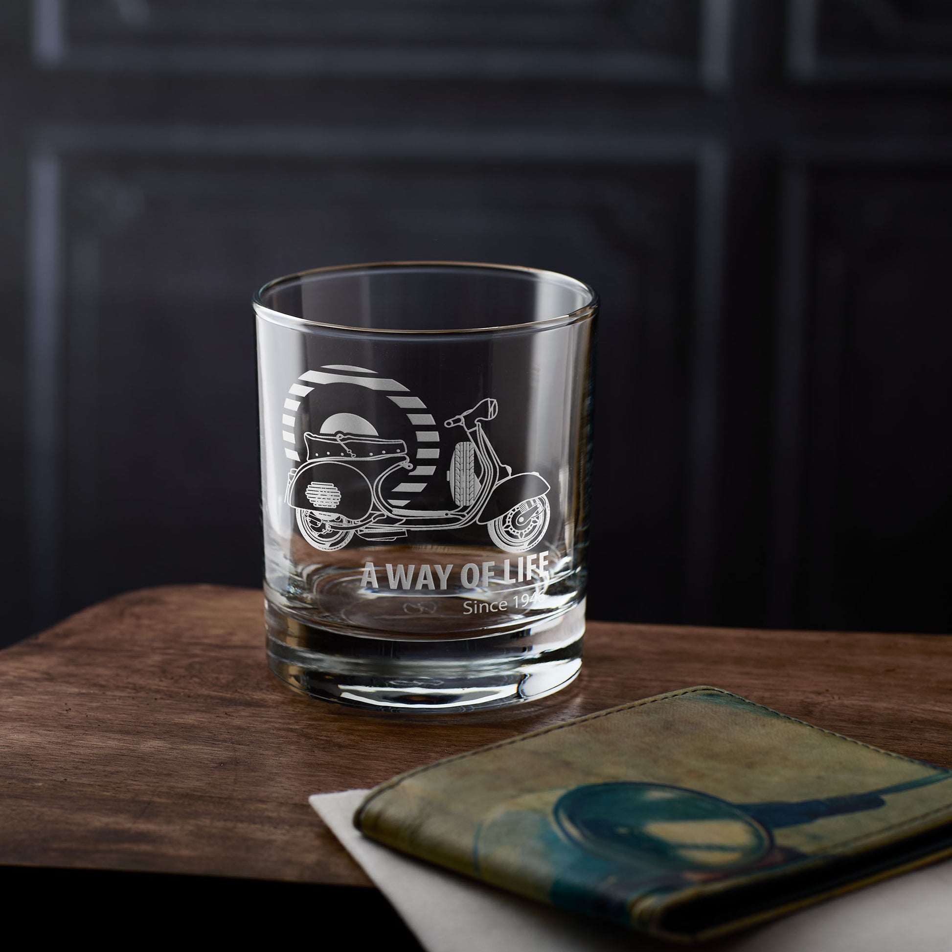 Whiskey tumbler with Vespa GS scooter engraving and personalised text on a wooden surface