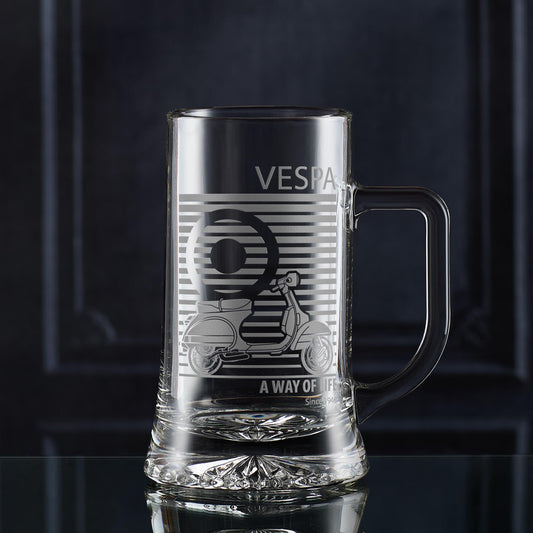 Clear glass beer tankard with Vespa PX design and text on a dark background