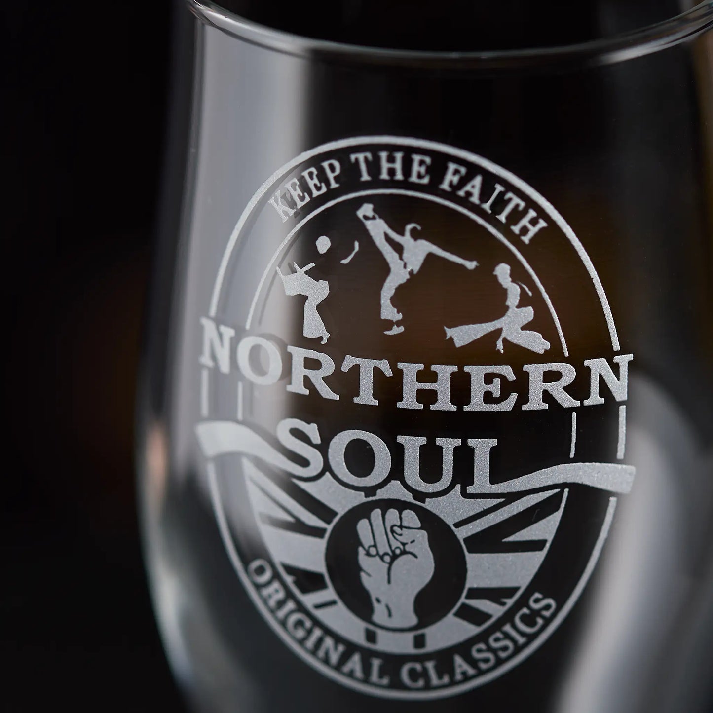 Glass with 'Northern Soul' clenched fist with three dancers and text on a dark background