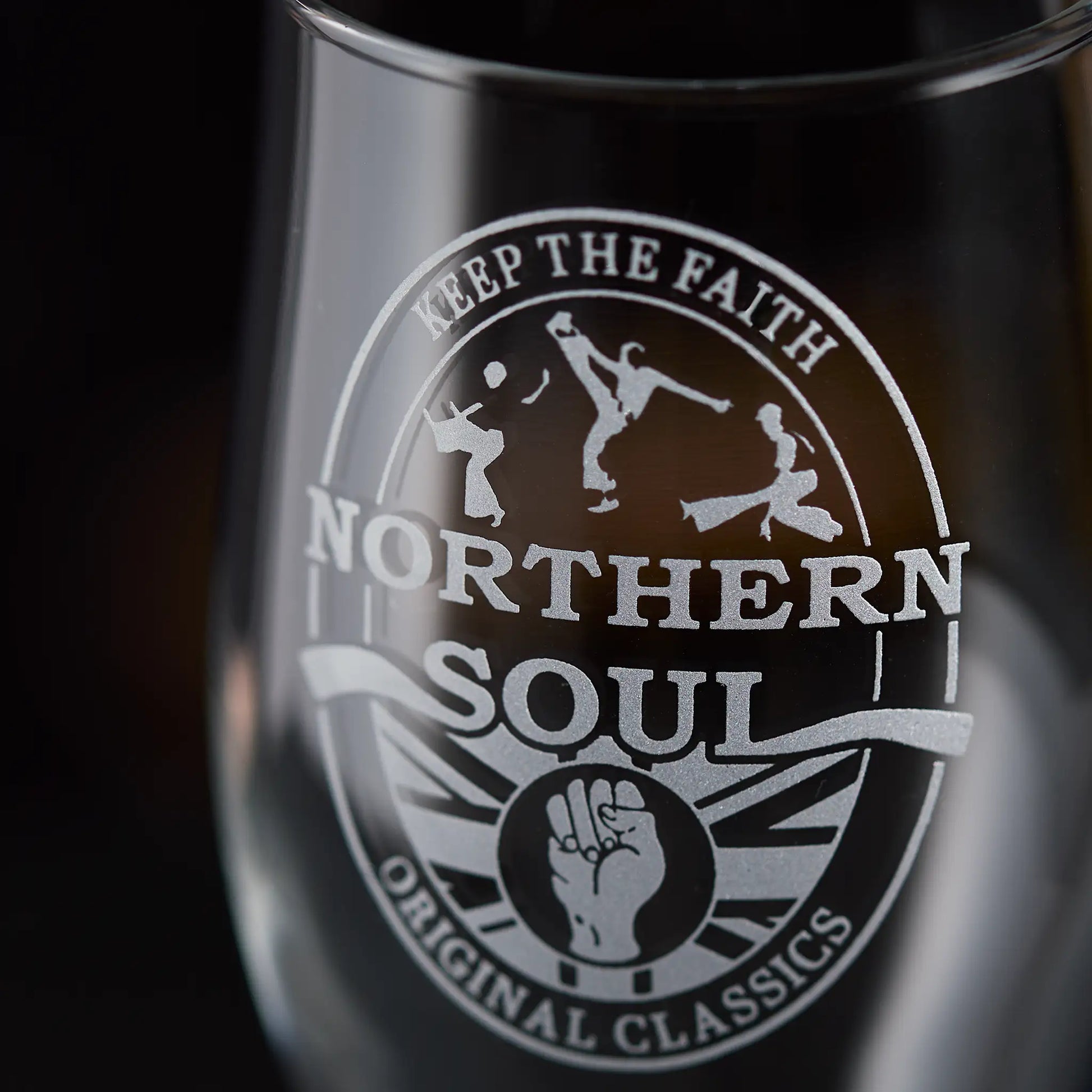 Glass with 'Northern Soul' clenched fist with three dancers and text on a dark background