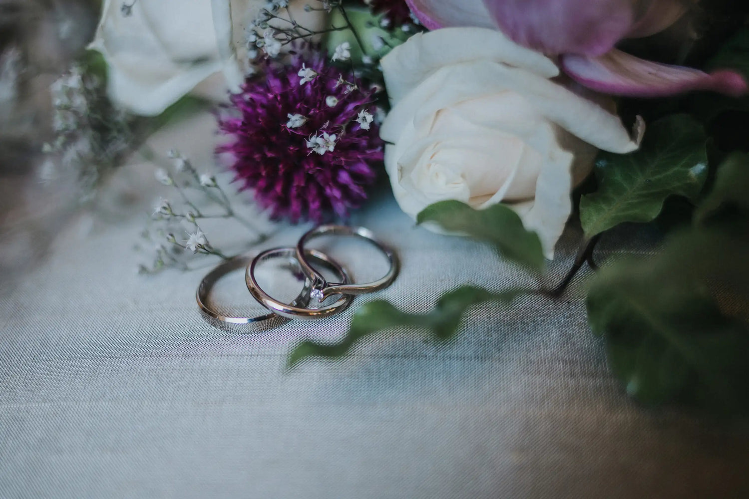Flowers with wedding rings on a textured surface